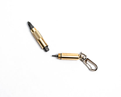 Overhead view of brass screwdriver keychain opened revealing bit storage